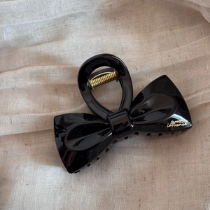 Détail d'une pince à cheveux noire avec inscription dorée Barrette La France élégante