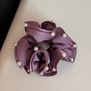 Close-up detail of mauve satin hair scrunchie with elegant white pearl bead decorations