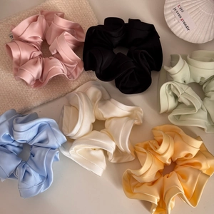 Elegant satin ruffle hair scrunchies in six pastel colors on a cozy decorative background