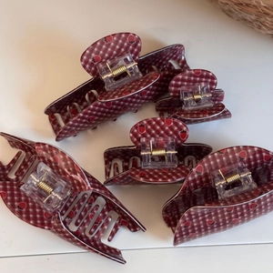 Detail view of five-piece strawberry pattern hair claw clips with golden metal springs