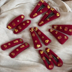 Detail view of 12 red felt hair clips with golden lucky coins and Chinese characters