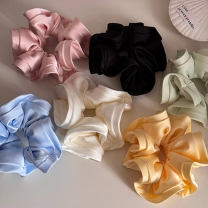 Close-up of colorful satin scrunchies set with soft silk texture and ruffle detail