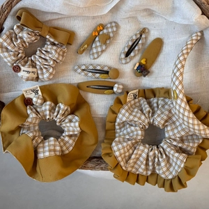 Close-up of yellow fabric scrunchies and hair clips set in a woven basket