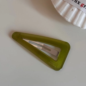 Nahaufnahme einer olivgrünen dreieckigen Haarspange mit France Handmade Beschriftung