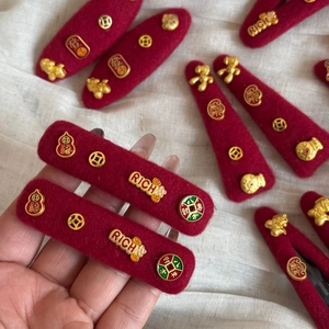 Chinese New Year red felt hair clips featuring gold lucky charms and rich text designs