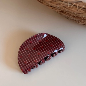 Detailed view of dark red plaid hair claw clip with strawberry elements and glossy resin finish