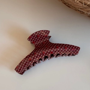 Detail view of the red plaid strawberry pattern hair claw clip with a glossy finish