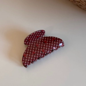 Close-up of strawberry print and red plaid pattern on a large hair claw clip accessory
