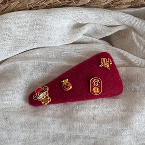 Detail of red felt hair clip with golden charms for Chinese New Year prosperity