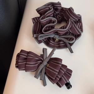 Dettaglio di elastico e fermaglio per capelli retrò a righe con ciondolo