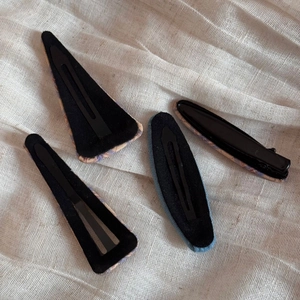 Detail of four-piece plaid fabric hair clips showing black velvet backing and metal base