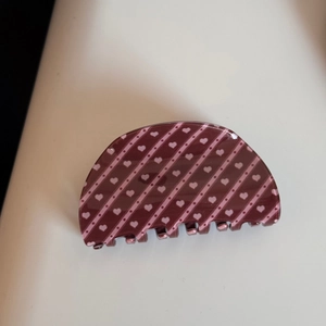 Vue détaillée de la grande pince à cheveux marron foncé avec motifs cœurs roses brillants