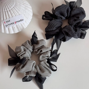 Detailed macro of black checkered and grey striped hair scrunchies with organza bows