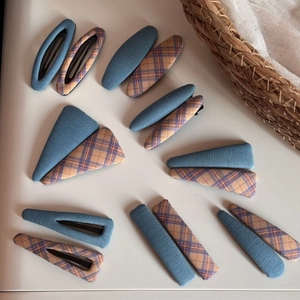 Detailed set of blue and plaid fabric hair clips in various geometric shapes on white