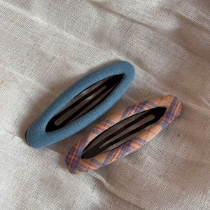 Detail showing blue denim and plaid fabric textures on oval BB hair clips