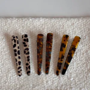 Detailed set of 6 leopard and tortoise shell pattern resin hair clips on soft white fabric