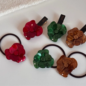 Dettaglio degli elastici e fermagli a fiore in acetato con testo France Handmade e cristalli