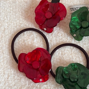 Dettaglio di elastici per capelli a fiore marmorizzato con strass su tessuto bianco