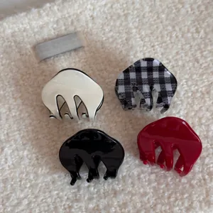 Set of four small acetate hair claws in black, cream, plaid, and deep red finishes