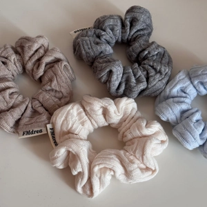Detailed close-up of knitted twist texture and small brand label on soft hairbands