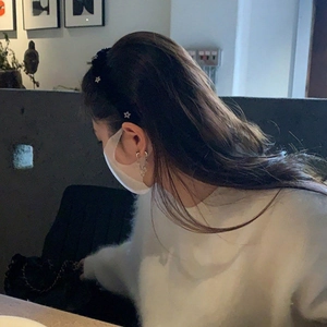 Detail eines süßen Anti-Rutsch-Stirnbands mit Sternen, getragen zu gemütlicher Strickmode