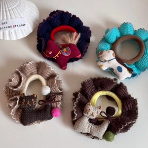 Gruppe von gestrickten Tier-Scrunchies mit Katzen- und Pferde-Stickerei auf weißem Grund