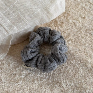 Close-up of grey knitted headband texture with premium woven fabric and side brand label