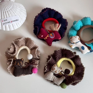 Set mit vier gestrickten Haargummis mit süßen Stofftieranhängern und bunten Pompons