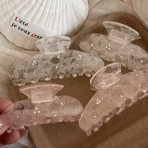 Lace rhinestone hair claw clips for women in white and pink displayed on tray