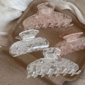 Detail view of lace pattern and rhinestones on hair clips on a vintage tray