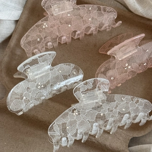 Detail view of lace texture and sparkling rhinestones on the medium hair claw clips