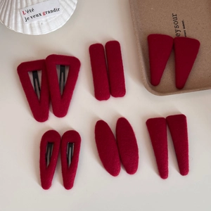Macro shot of assorted deep red velvet hair clips with elegant felt texture and metal base