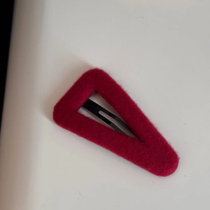 Macro detail of wine red velvet triangular BB hair clip with black metal spring fastener