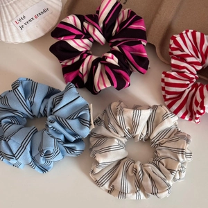 Detail of four colorful striped fabric scrunchies arranged with elegant decor