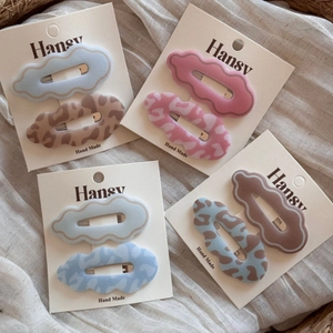 Detailed view of handmade velvet wave hair clips in assorted colors on card packaging