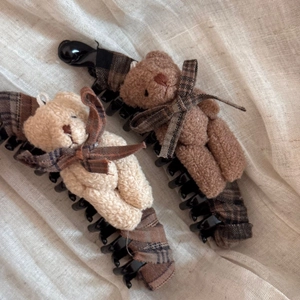 Dettaglio di fermagli per capelli orsetto di peluche con fiocchi a quadri e tessuto