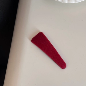 Detailed close-up showing the soft velvet texture of the burgundy red hair clip fabric