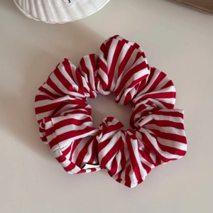 Detailed close-up of a red and white striped scrunchie made of soft elastic cotton