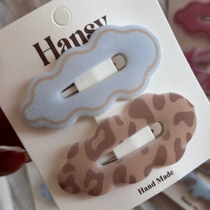 Close-up of leopard print and blue cloud-shaped velvet hair clips on display card