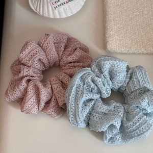 Close-up of pink and blue lace scrunchies with intricate floral mesh texture and soft pleats