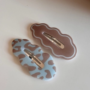Detail view of leopard print and solid brown flocked cloud-shaped BB hair clips