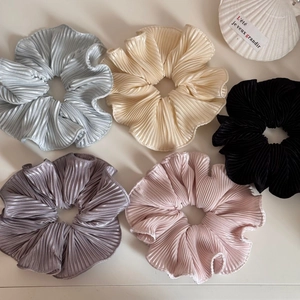 Five pleated oversized scrunchies in pastel colors on a clean white background