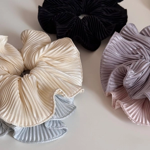 Detail of five large pleated satin scrunchies in cream, blue, purple, pink and black colors
