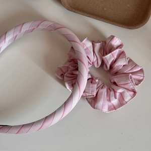 Detailansicht von rosa-weiß gestreiftem Haargummi und Stirnband-Set aus Stoff