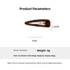 Detailed macro view of acetate hair clip with tortoiseshell pattern and metal spring mechanism