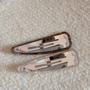 Close-up of teardrop acetate hair clips with tortoiseshell and marble patterns on fleece