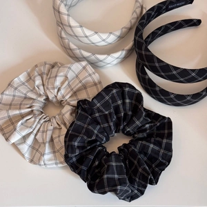 Detail of handmade black and white plaid headbands and scrunchies set on white background