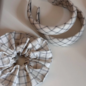 Detailed view of checkered scrunchie and padded headbands set in minimalist grid pattern