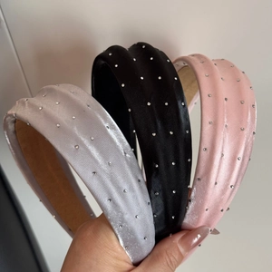 Détail de trois serre-têtes rembourrés en satin avec des strass brillants décoratifs