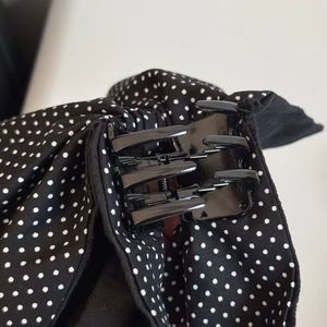 Detail of internal spring mechanism and polka dot fabric on a black hair claw clip
